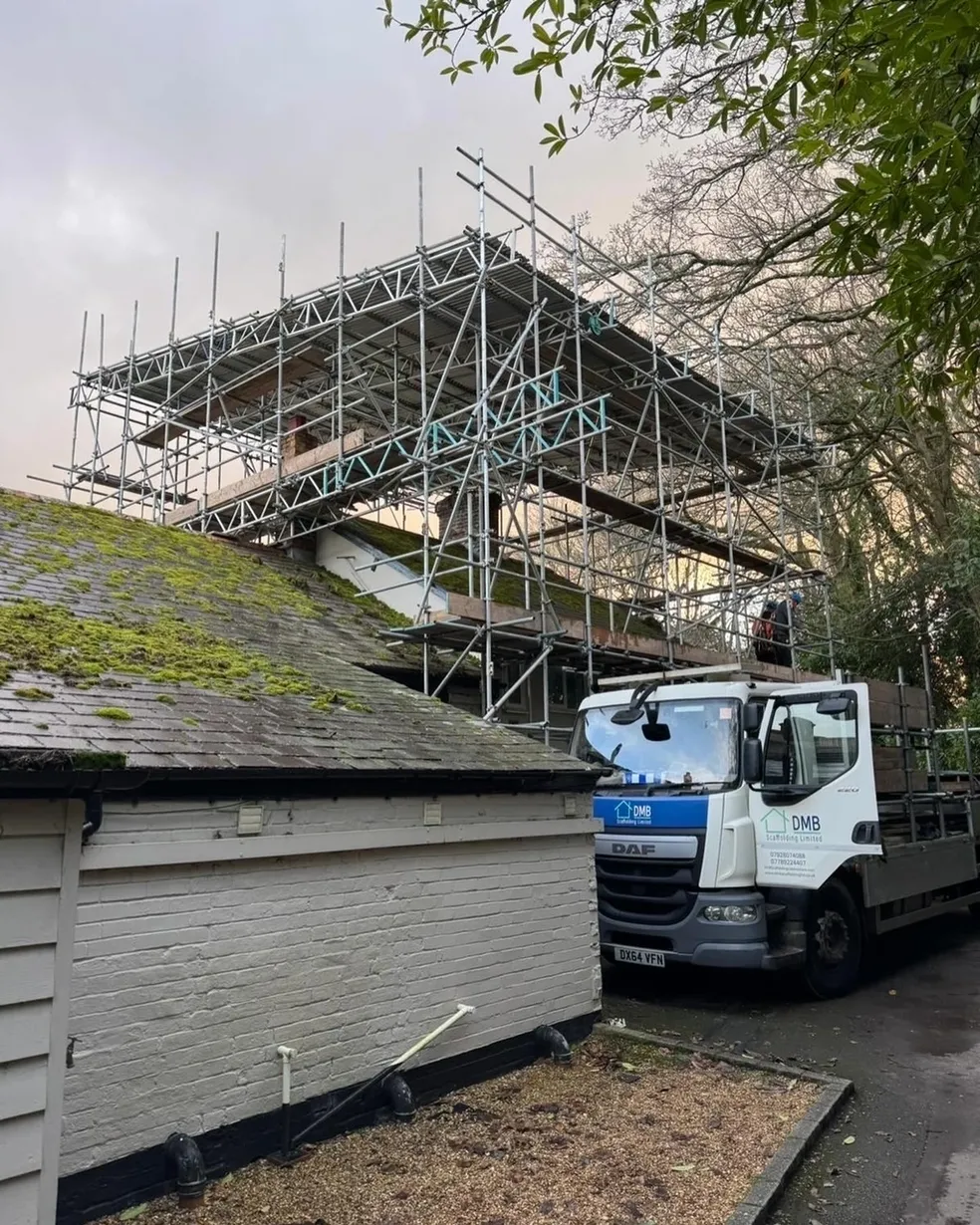 DMB Scaffolding truck parked beside a roof scaffold on a residential project